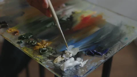 Close-up, Artist's Hand Stirs Brush Oil Paint on Glass Table Video stock 155207259