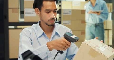 Close-up Asia man sit front desk computer use barcode machine scan record. Stock Footage 229649476