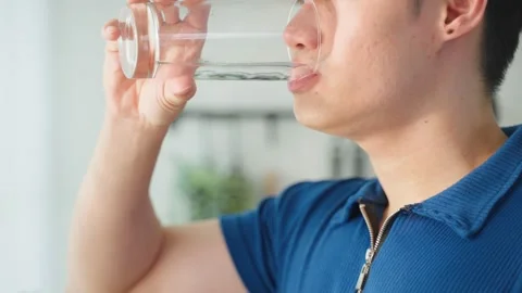 Close up of Asian active strong man drinking clean water in kitchen. Stock Footage 171261553