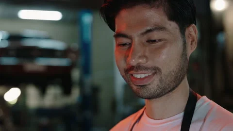 Close up of asian auto mechanic using laptop for checking car standing in an Stock Footage 303779031