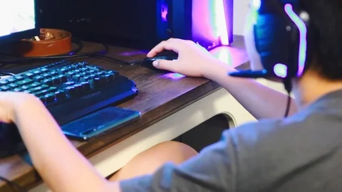 Close up of Asian boy playing game on his gaming computer with RGB gaming gear Stock-Footage 107907729