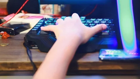 Close up of Asian boy playing game on his gaming computer with RGB gaming gear Stock Footage 107907818