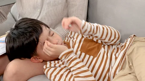 Close up of Asian boy playing game on tablet and feeling sleepy while lying.. Stock Footage 249583205