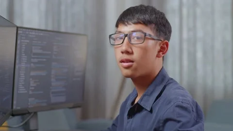 Close Up Of Asian Boy Programmer Smiling To Camera While Creating Software Stock Footage 233463827