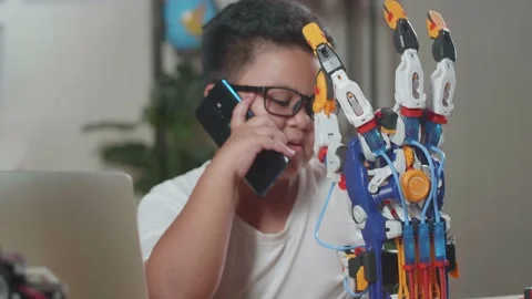 Close Up Of Asian Cute Boy Talking On Smartphone While Working About A Cyborg Stock Footage 212020938