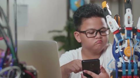 Close Up Of Asian Cute Boy Using Smartphone While Working About A Cyborg Stock Footage 212020723