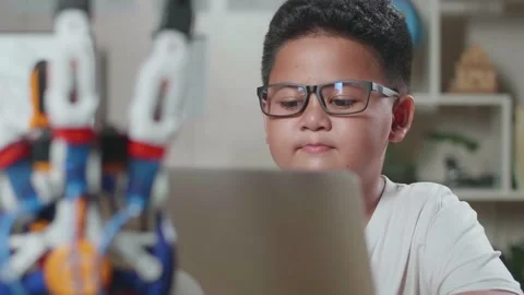 Close Up Of Asian Cute Boy Working About A Cyborg Hand On A Laptop At Home Video stock 212019957