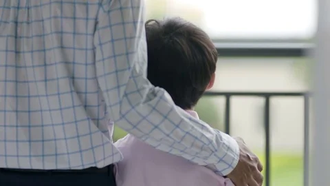 Close up of Asian father pulling son toward him on balcony Stock Footage 78202034