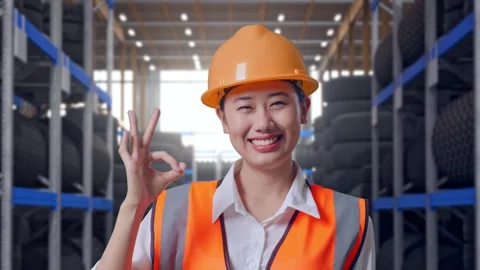 Close Up Of Asian Female Engineer Smiling Showing Okay Gesture Tire Warehouse Stock Footage 341788418