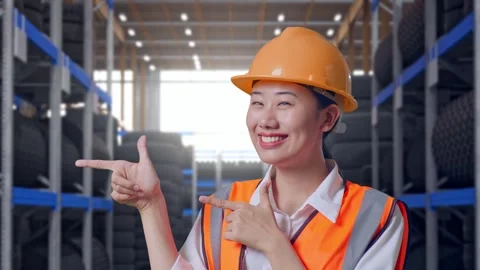Close Up Of Asian Female Engineer Smiling And Pointing To Side at Tire Warehouse Video stock 341788460