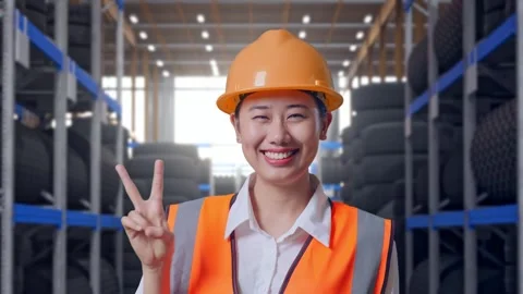 Close Up Of Asian Female Engineer Smiling Showing Peace Gesture Tire Warehouse Stock Footage 341788510