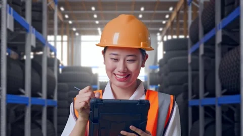 Close Up Of Asian Female Engineer Taking Note On The Tablet at Tire Warehouse Stock Footage 341788550