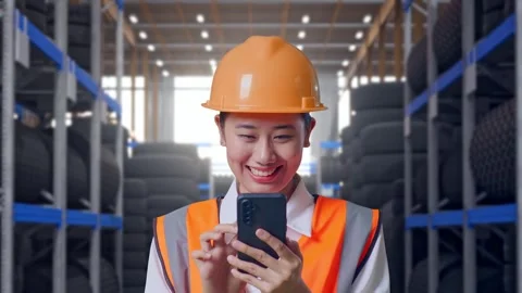 Close Up Of Asian Female Engineer Using Smartphone at Tire Warehouse Video stock 341788573