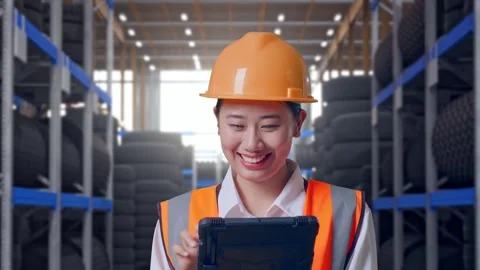 Close Up Of Asian Female Engineer Working On A Tablet at Tire Warehouse Stock Footage 341788555