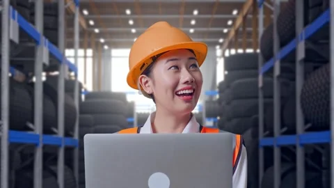 Close Up Of Asian Female Engineer Working On A Laptop at Tire Warehouse Stock Footage 341788614