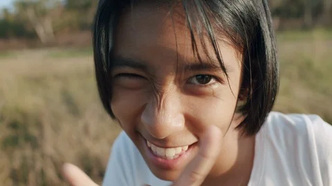 Close up of Asian girl sing while looking camera  midst of nature Stock Footage 123645919