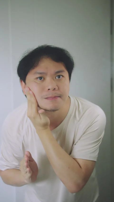 Close-up of Asian Man Checking Skin Aging and Wrinkles in Bathroom Mirror Stock Footage 337769424