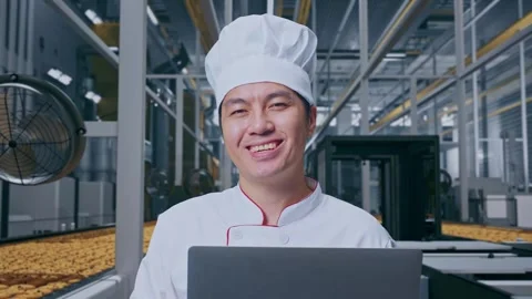 Close Up Of Asian Man Chef Using A Laptop And Smiling In Cookie Factory Stock Footage 318081651