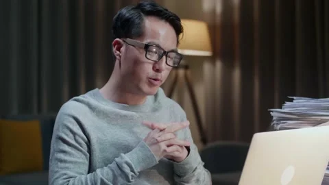 Close Up Of Asian Man Explaining Work While Having Video Call On Laptop At Home Stock Footage 196928347