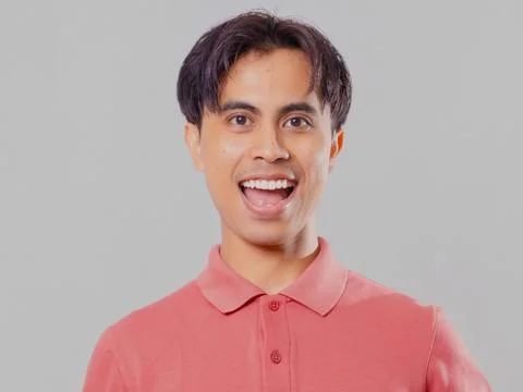 Close-up of asian man facing forward smiling broadly on plain background Stock Photos