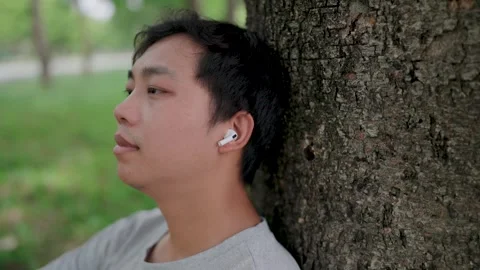 Close-up Asian man leaning on a tree thinking outside sitting on floor, He think Stock Footage 283187207