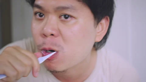Close-up of Asian Man Looking at Mirror While Brushing Teeth,  Stock Footage 337769185