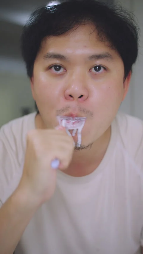 Close-up of Asian Man Looking at Mirror While Brushing Teeth, Morning Routine Stock Footage 337769528
