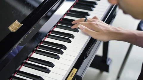Close up of Asian man playing upright piano to practice his music lesson Stock Footage 112671430