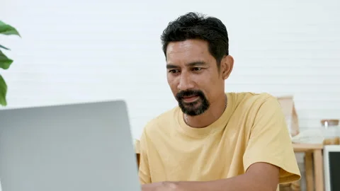 Close-up Asian man sitting checking younger brother's work on holiday, Stock Footage 241920719