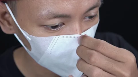 Close up of Asian man wearing white protective face mask for healthcare Stock Footage 345330841