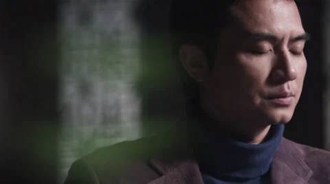 Close up of Asian meditating man opening eyes in slow motion Stock Footage 30477487