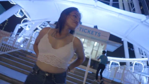 Close up of Asian model posing in front of the big wheel at the funfair Stock Footage 211381934