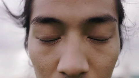 Close-up of Asian young man looking at camera outdoor Stock Footage 196472357