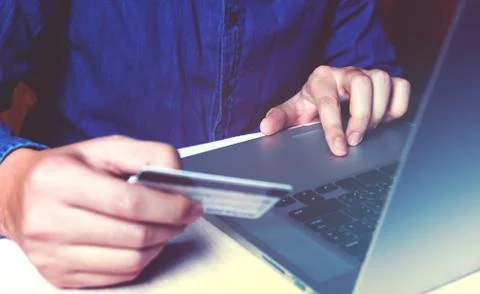 Close up asian young man using laptop and holding credit card with shopping.. Stock Photos