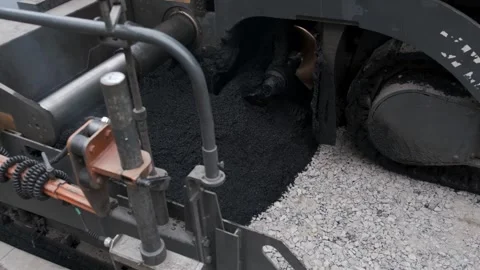 Close up of asphalt paver distributing hot tarmac over gravel Stock Footage 339802371
