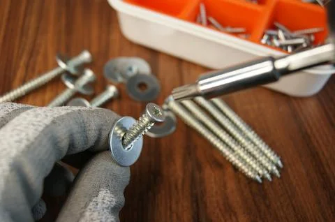 A close-up of the assembler's work process. Screw in the hand of the assembler Stock Photos