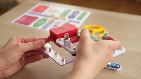 Close-up of assembling simple electronic circuit, educational STEM kit. Basic Stock Footage 346721577