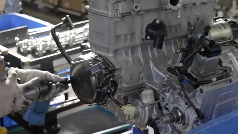 Close up of an assembly line worker using a pneumatic screwdriver to fasten a Stock Footage 333399732