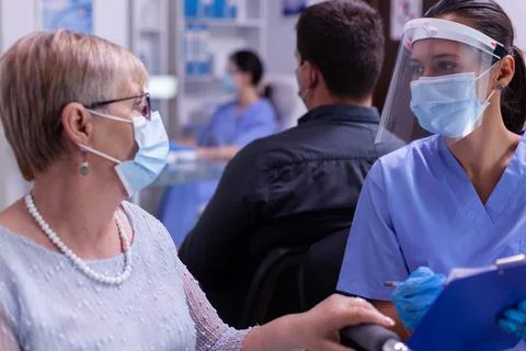 Close up of assistant explaining diagnosis to paralyzed old woman Foto stock
