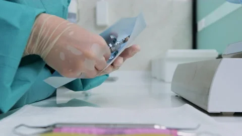 Close-up of assistant puts dental tool syringe into craft package. Side view Stock Footage 131684082