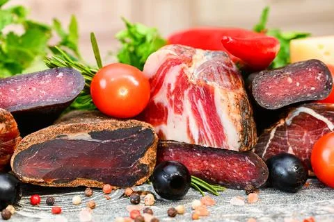 Close up of assorted dry-cured meat on the wooden background Foto stock