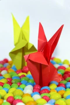 Close up of an assorted jelly beans and origami rabbits from paper. Stock-Fotos