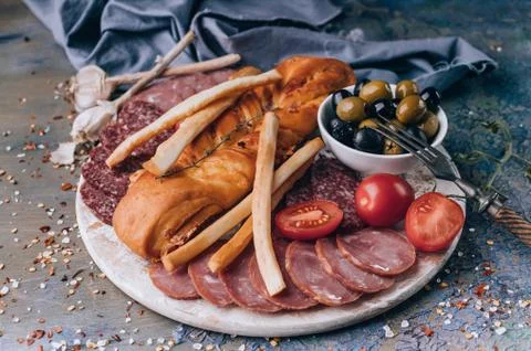 Close-up assorted from meat and cheese on a round chopping board. Raw smoked  Foto stock