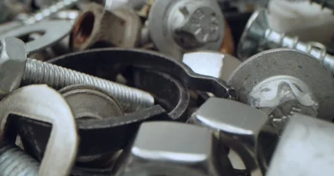 Close-up of assorted nuts, bolts, and fasteners. A scattered pile of shiny metal Stock Footage 313961119