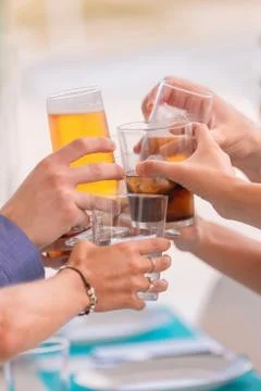 Close up of an assortment of hands doing a toast with different drinks on an  Stock Photos