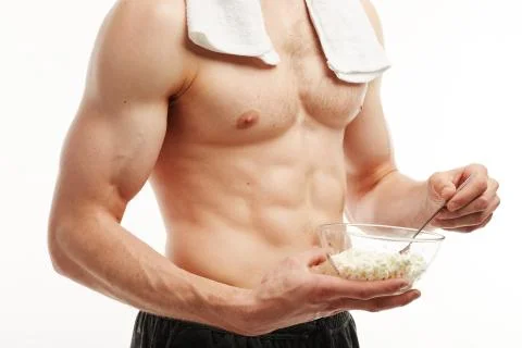 Close up. The athlete eats cottage cheese on a white background Stock Photos