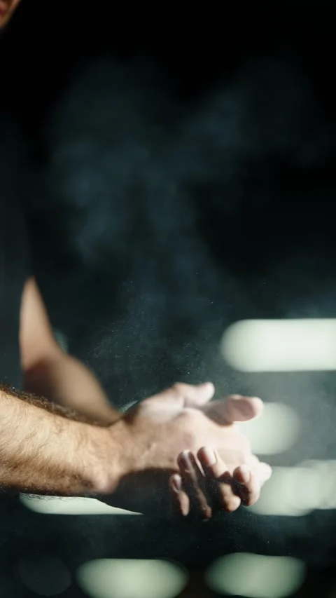 Close-up of an athlete preparing for an intense gym workout, clapping chalked Stock Footage 329555890
