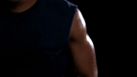 Close up of an athletic ethnic man jumping back forth while training in a dark Stock Footage 33834500