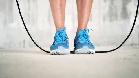 Close up of athletic male working out with a skipping rope in blue shoes. Stock Footage 112656316