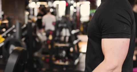 Close-up of athletic man doing biceps exercises in the gym with dumbbells. Side Stock Footage 158759628